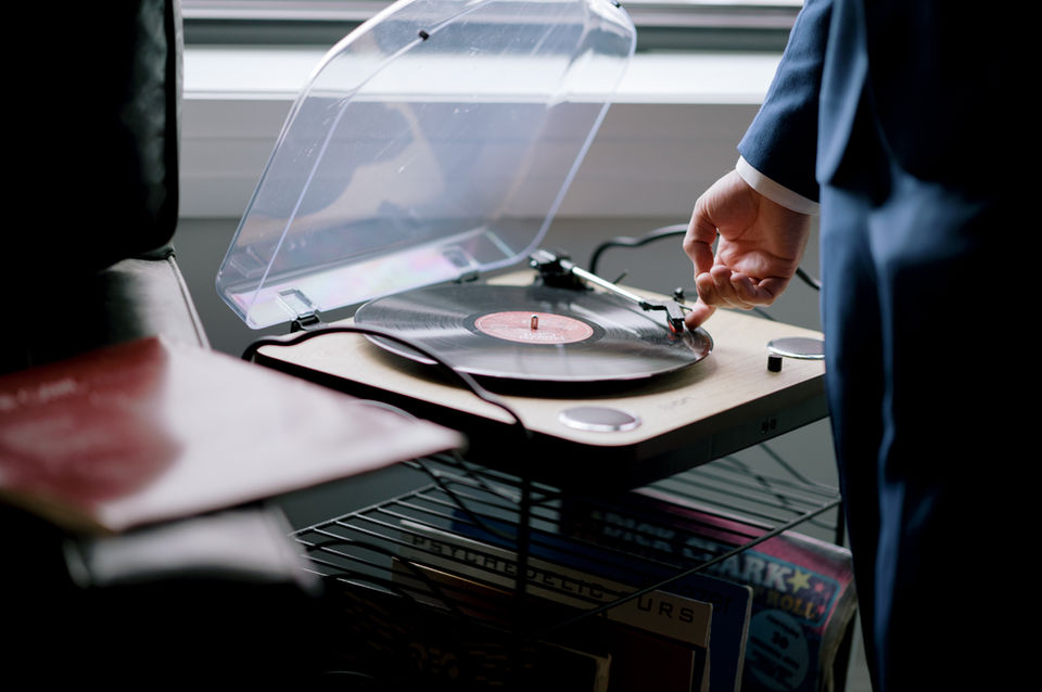 Hand putting vinyl record on record player