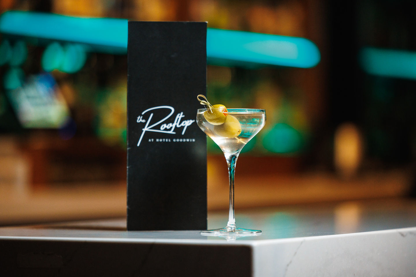 Martini sitting next to The Rooftop menu