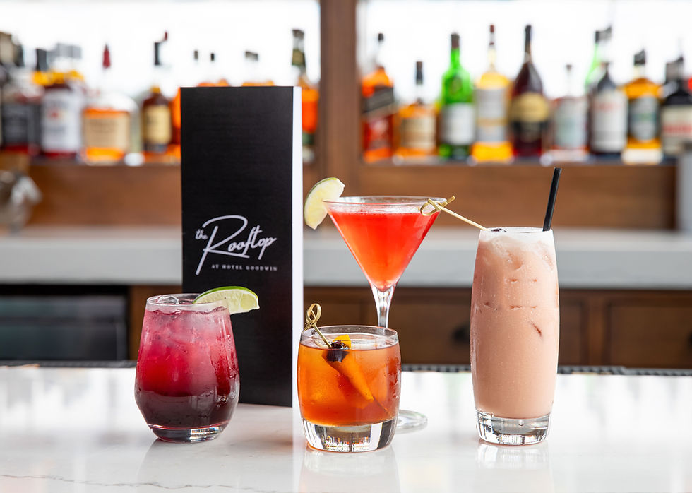 Four colorful cocktails lined up on a bar