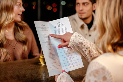handing pointing to Rooftop drink menu