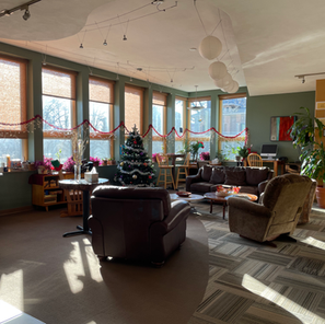 Brightly lit lobby with cozy chairs decorated for the holidays.
