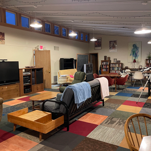 Attic den-like room with comfortable seating options and colorful carpet blocks.