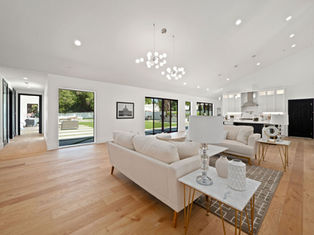 A large and spacious, modern, and bright living room with parquet floors, high ceilings and an open kitchen.