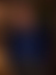 AI-generated full-length portrait of a mature, stocky man with glasses wearing an open royal-blue velvet jacket, blue shirt, charcoal trousers, and burgundy suede loafers.