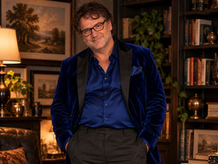 AI-generated full-length portrait of a mature, stocky man with glasses wearing an open royal-blue velvet jacket, blue shirt, charcoal trousers, and burgundy suede loafers.