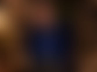 AI-generated full-length portrait of a mature, stocky man with glasses wearing an open royal-blue velvet jacket, blue shirt, charcoal trousers, and burgundy suede loafers.