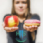 Woman holding a red apple in one hand and a pink sprinkled donut in the other. "Hi5 Smiles Dental" logo present. Neutral background.