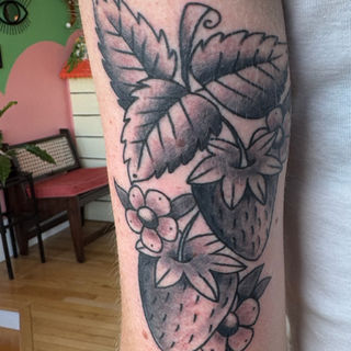 traditional style black and gray strawberry tattoo on arm