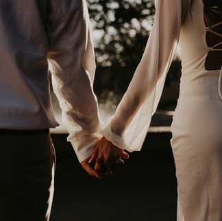 Close up of bride and groom holding hands in golden hour light, showcasing authentic natural light wedding photography in Dallas.