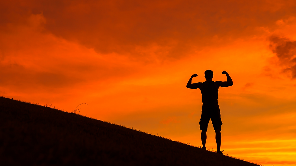 A man standing on a hill, muscles flexed in a power stance, with an orange sunset.