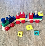 Jeu de construction à bas de formes percées à placer sur une train.