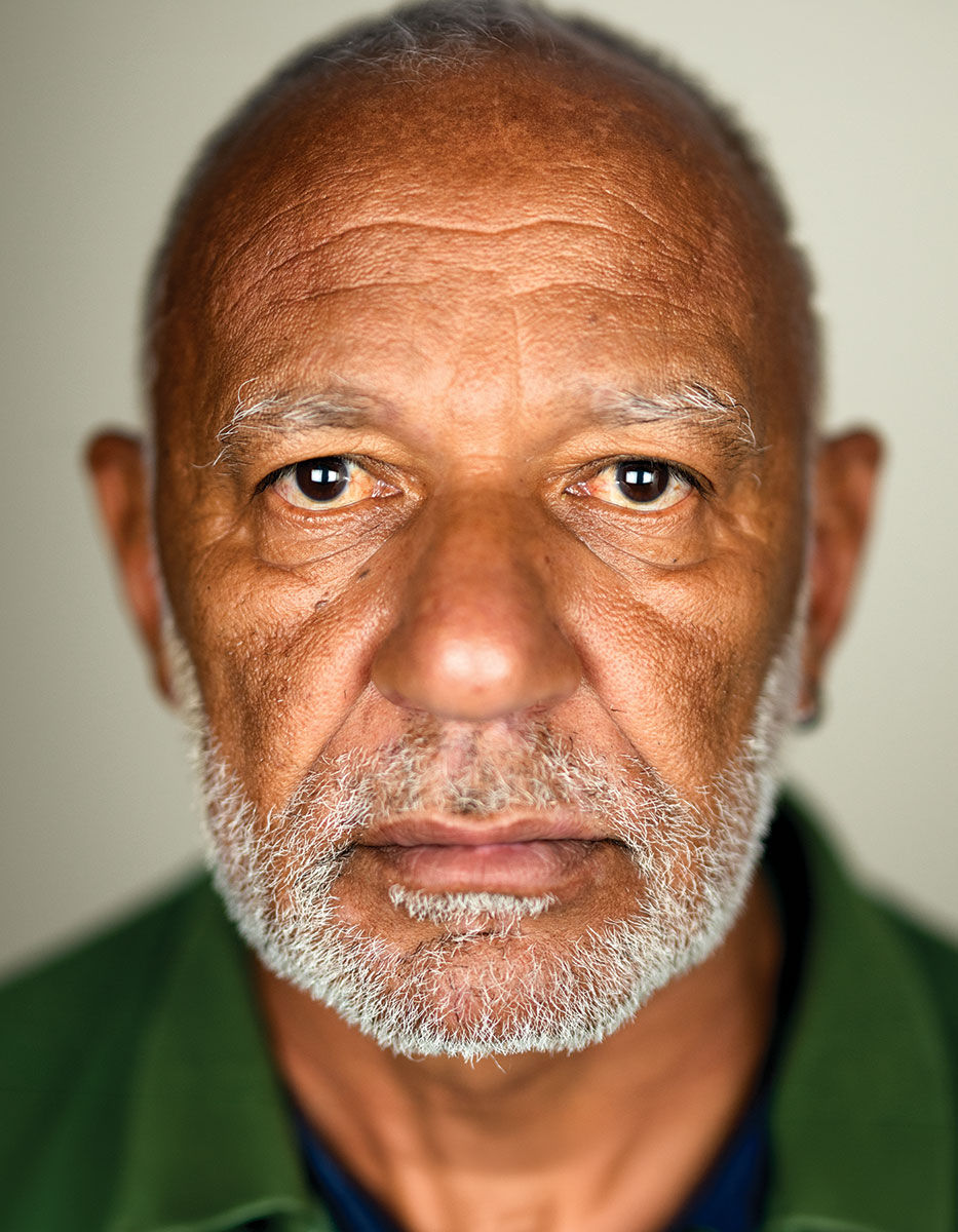 O retrato de um homem de alguma idade, chamado Professor. Ele tem um olhar direto, em um retrato simples, olhando direto para a câmera, com um fundo branco.