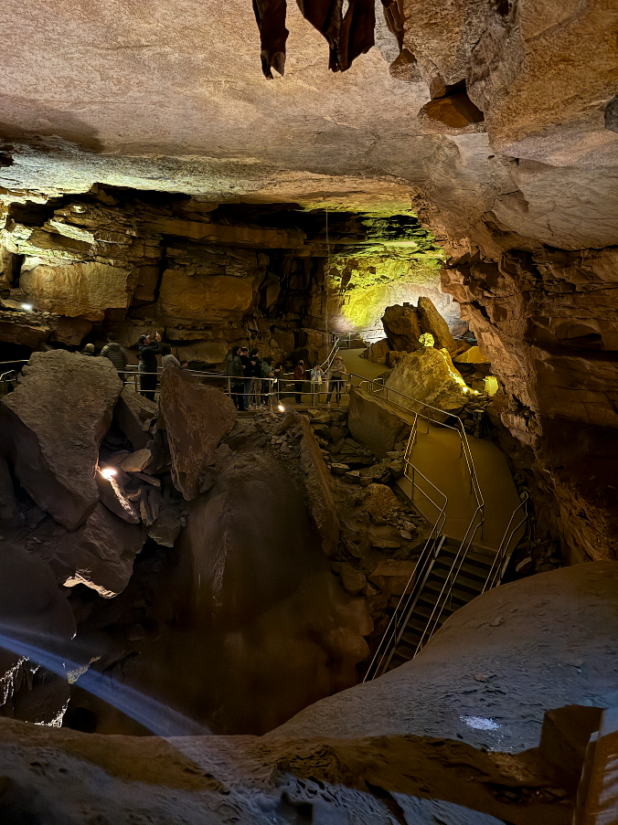 View of the inside of Mammoth Cave, with several walkways and staircases visible with railings.