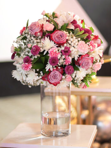 Centro de mesa grande con flores como rosas, claveles y más en jarrón de vidrio perfecto para bodas, quinceaños, baby shower en la ciudad de Panamá.