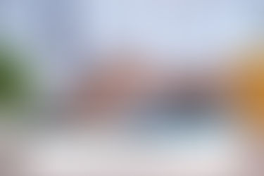 Hands on a blue calculator, person in a plaid shirt. A plant and yellow cup nearby. Text reads: What Happens When You Miss the Tax Deadline?