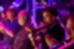 Musicians playing trombones in a brass section on stage