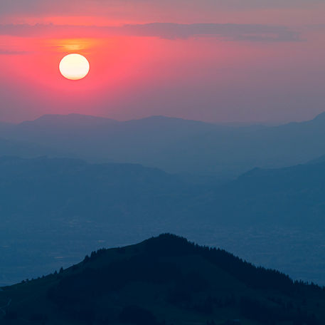Sonnenaufgang über den Bergen. Diese liegen in mehreren schichten hintereinander
