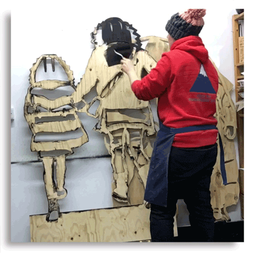 This photo shows Martha Ellis in her studio as she paints one of the panels for her sculpture black