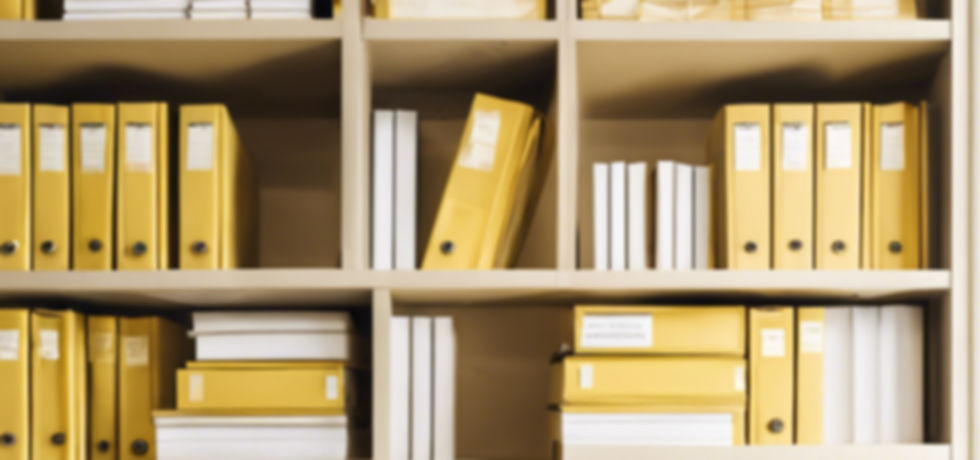 Book shelf with organized, labeled, yellow binders