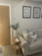 Grey living room with wooden side table and framed prints
