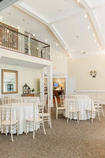 	6.	Spacious reception hall with a high ceiling, elegant lighting, and neutral decor for a timeless wedding setting.