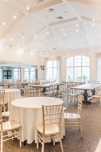 	7.	Beautifully arranged wedding reception space with floor-to-ceiling windows and gold Chiavari chairs.