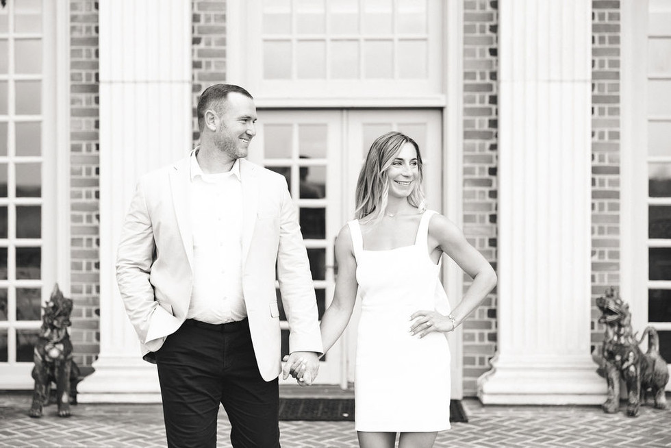 	5.	Couple standing in front of the grand brick façade at the Estate at River Run during engagement photos.