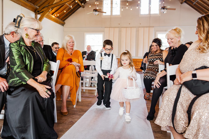 Ring bearer and flower girl walking down the aisle during a wedding ceremony at The Schoolhouse at Hawthorne in Richmond, VA.