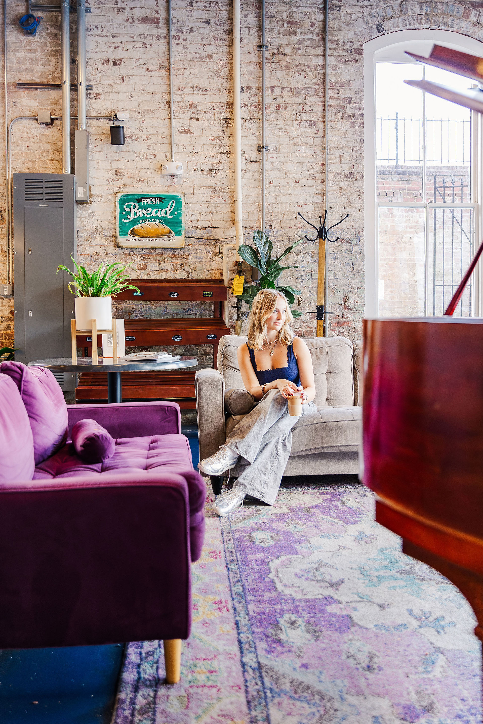 High school senior sitting in a cozy lounge area in Richmond, VA, for a relaxed and modern senior portrait.