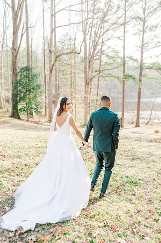 9. Bride and groom sharing a quiet moment while holding hands in the woods