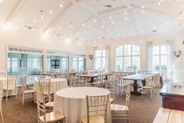 	5.	Bright and airy wedding reception space with white table linens, Chiavari chairs, and large windows at The Mill at Fine Creek.