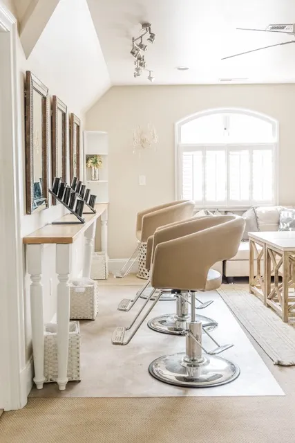	13.	Professional bridal beauty station with salon chairs and wall-mounted mirrors in a softly lit space.