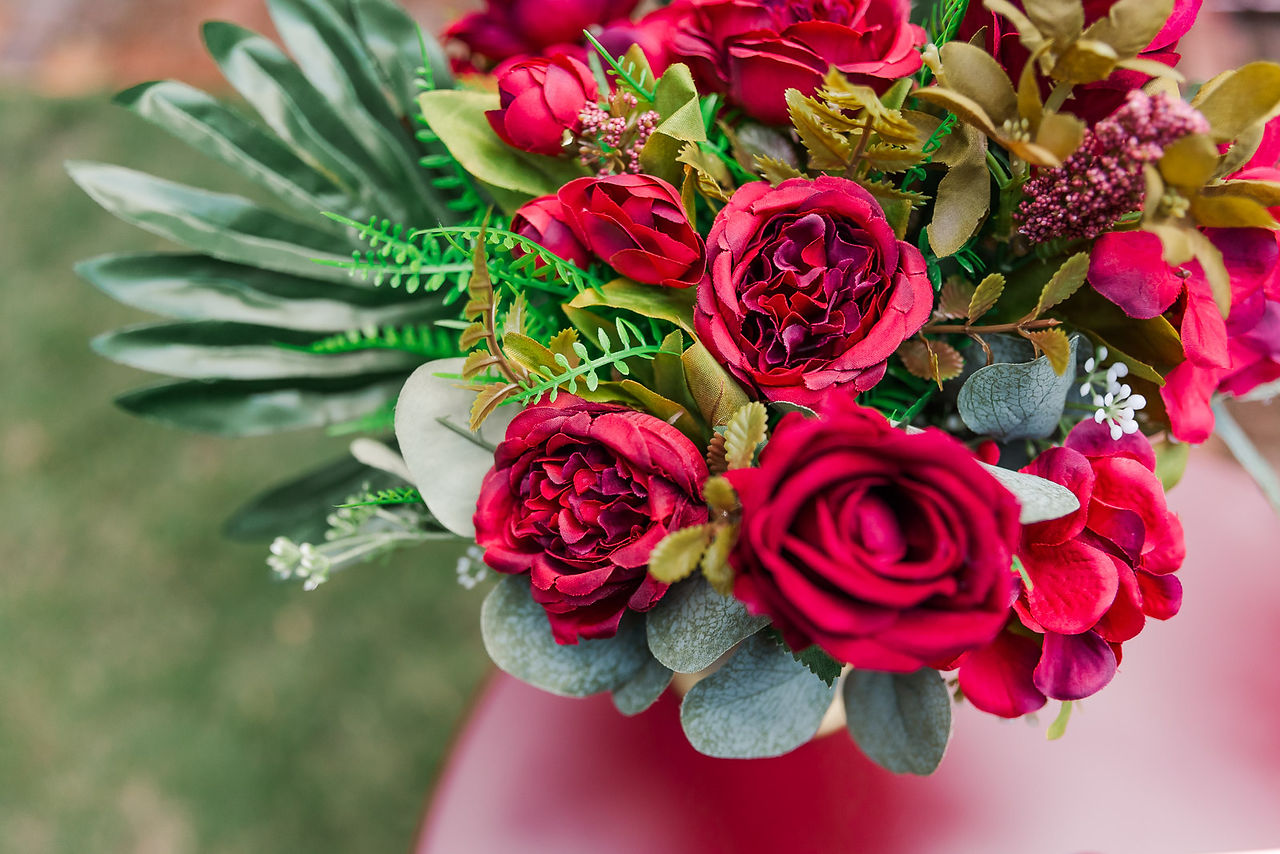 	7.	Close-up of deep red roses in a floral arrangement with greenery.