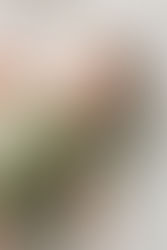 3. Baby lying on bed in green romper looking at camera