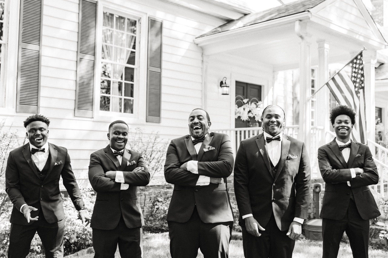 	8.	Groomsmen standing together outside Wrexham Hall in matching black tuxedos.