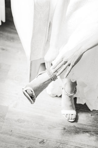 17. Bride adjusting shoes before wedding ceremony