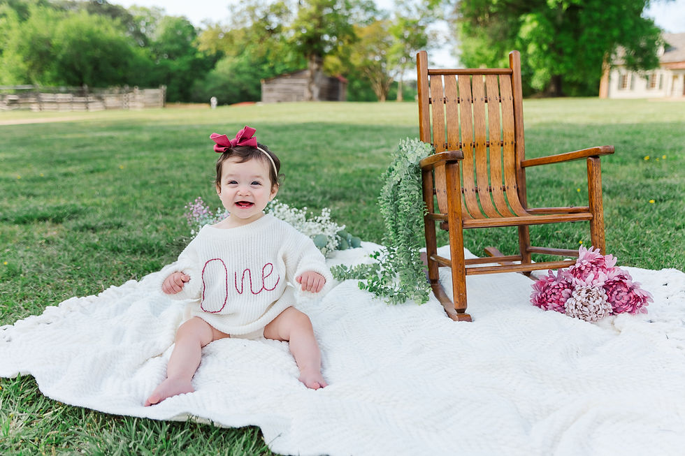 Baby girl laughing at the camera during a smash the cake session in Richmond, VA.