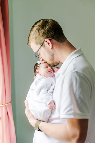 1️⃣7️⃣ Dad gazing down at newborn baby girl with love.