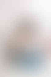 7. Richmond photographer photographing two baby girls during newborn session on white blanket.