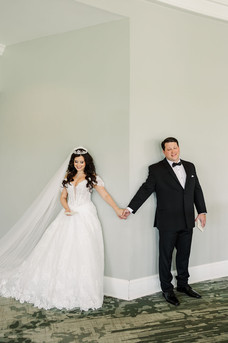 1. Bride and groom holding hands around a wall before the ceremony — emotional first-touch moment captured by Richmond wedding photographer at The Dominion Club.