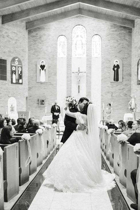 5. Black and white photo of couple sharing first kiss and walking out of church — timeless Richmond wedding photographer image.