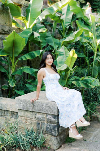 17. Gabi sitting by tropical greenery during Maymont Park senior portraits