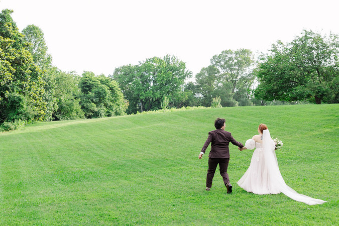 	15.	Bride and groom running playfully across open green field
