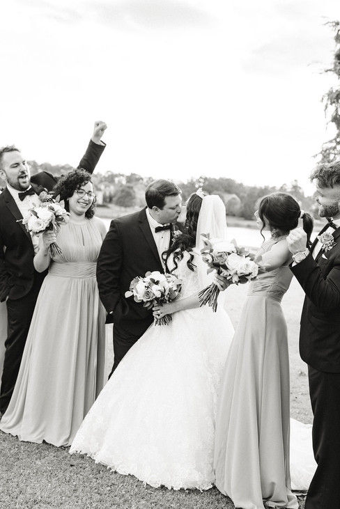5️⃣ Black and white photo of wedding party cheering for the newlyweds — timeless Richmond wedding photographer image.