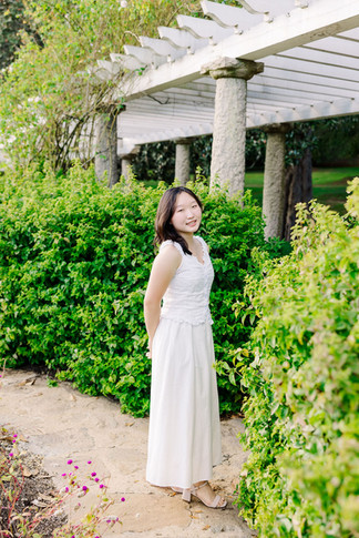 Portrait of a young girl in a white dress posing gracefully in the Maymont gardens, Richmond VA.