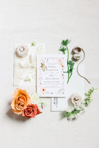 18. Wedding invitation flat lay with copper florals and rings at Antebellum of New Kent
