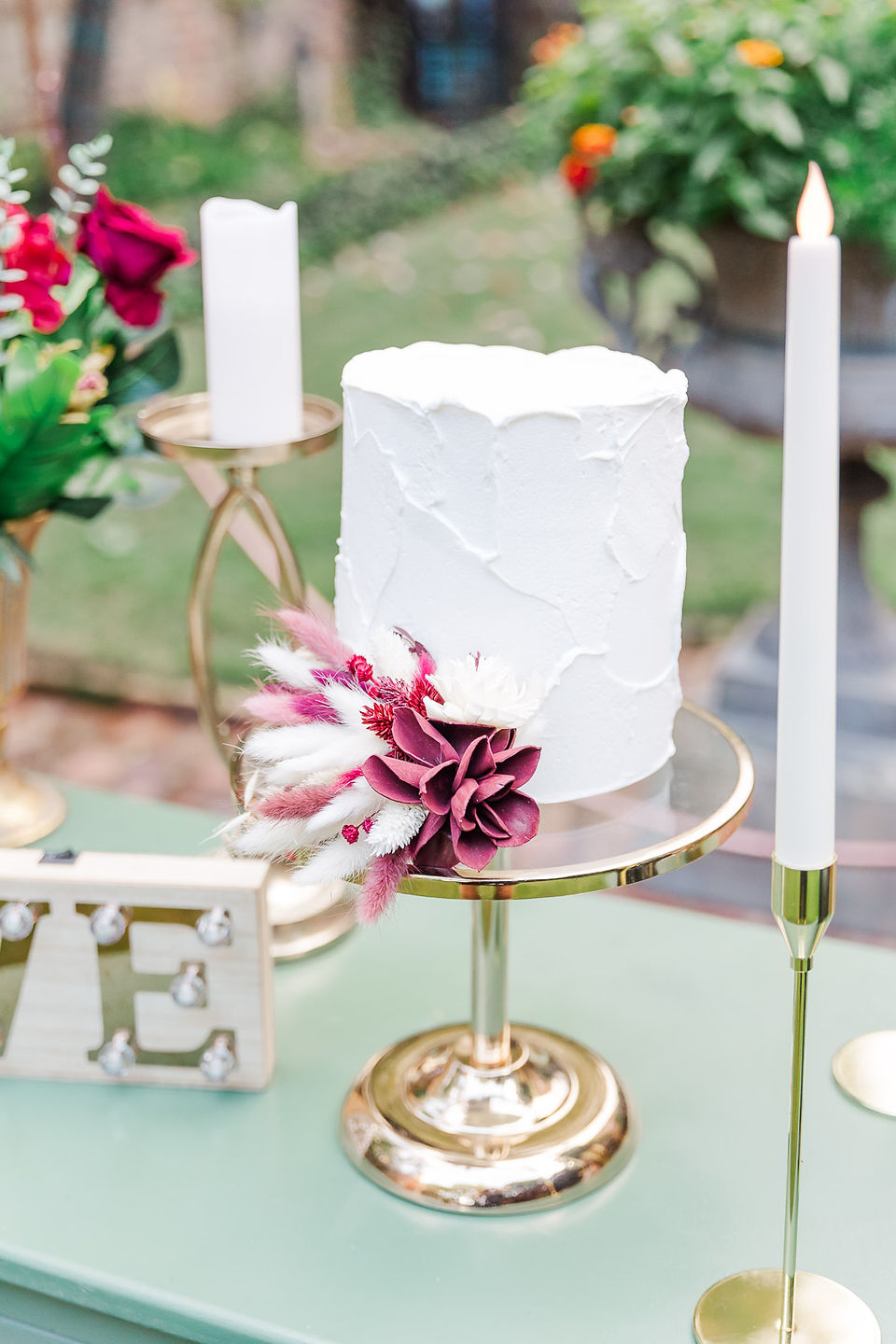 	3.	Elegant wedding cake with floral decorations on a gold stand.