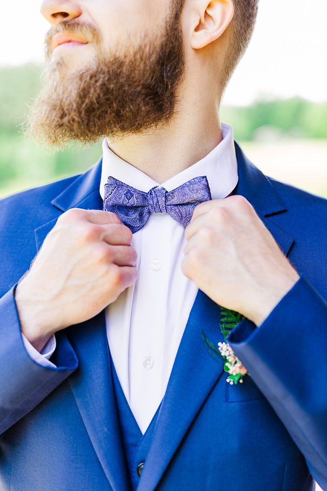 	6.	Groom adjusting purple bow tie for wedding