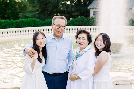 Grandfather smiling and hugging his daughters and granddaughter during their Maymont family session.
