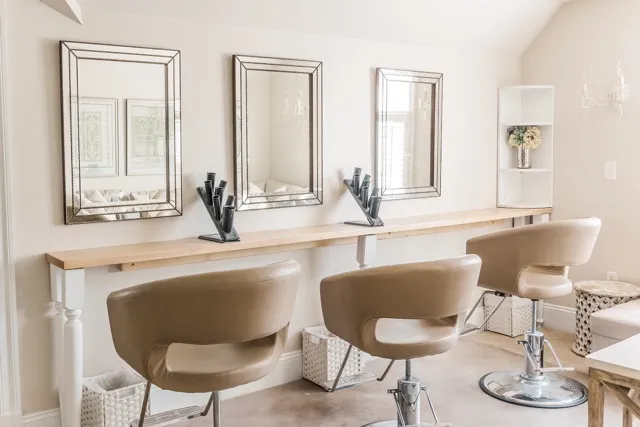	10.	Modern bridal suite featuring salon-style chairs, soft lighting, and mirrors for wedding preparations.